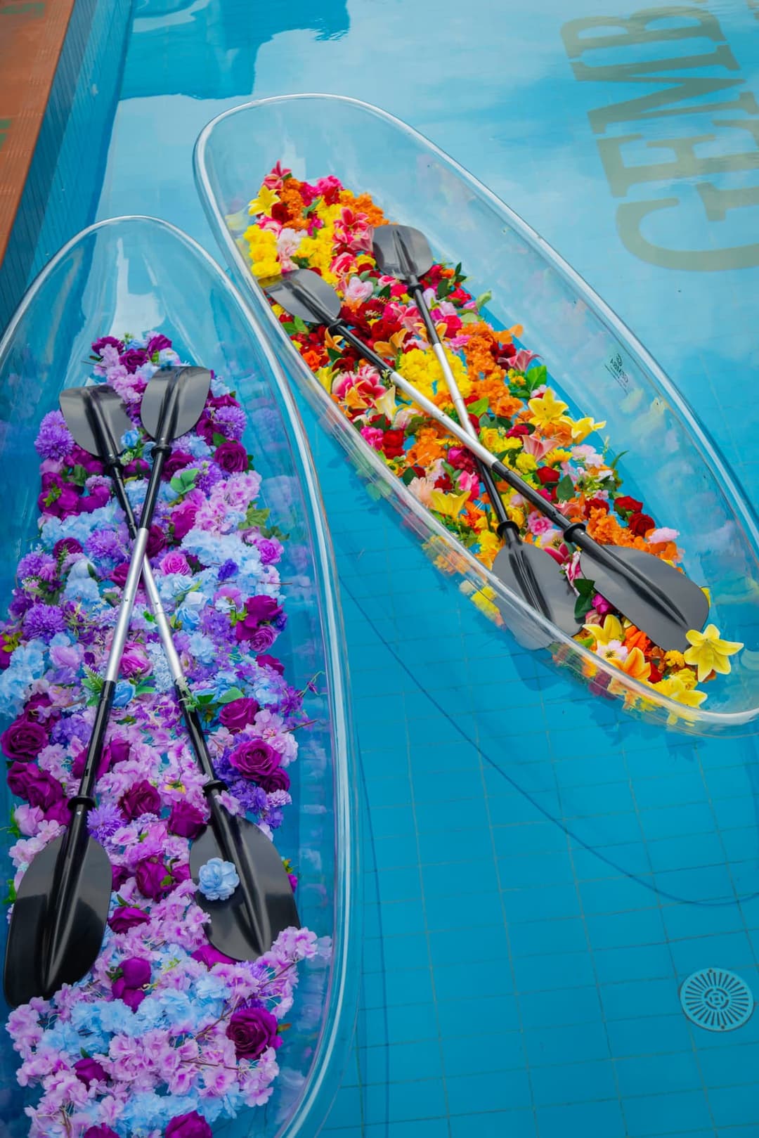 Flower-filled clear boats floating in a Gemba pool